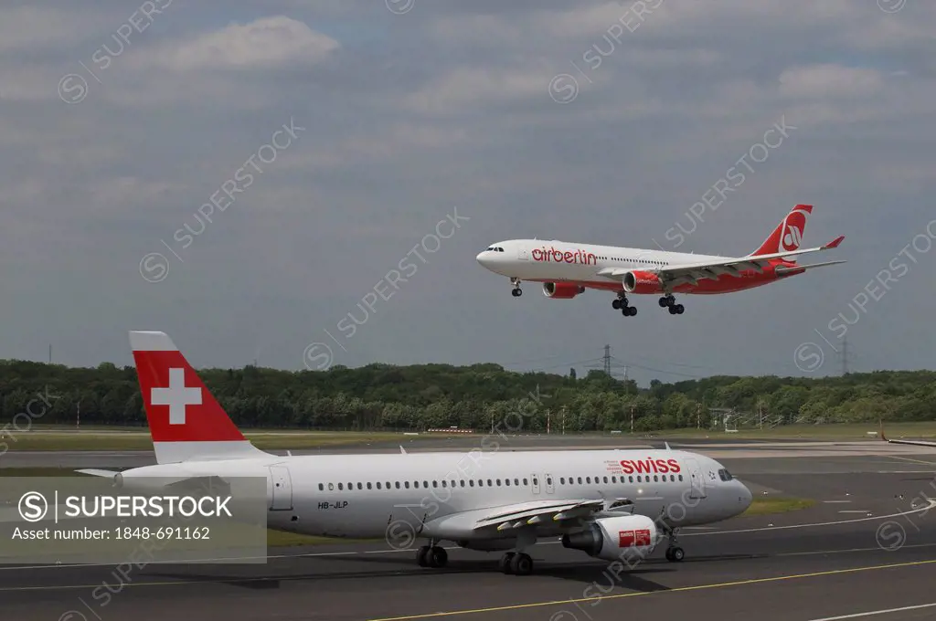 Passenger airplane of Swiss International Air Lines Ltd. on the runway, behind an airberlin airplane departing, Duesseldorf International Airport, Due...