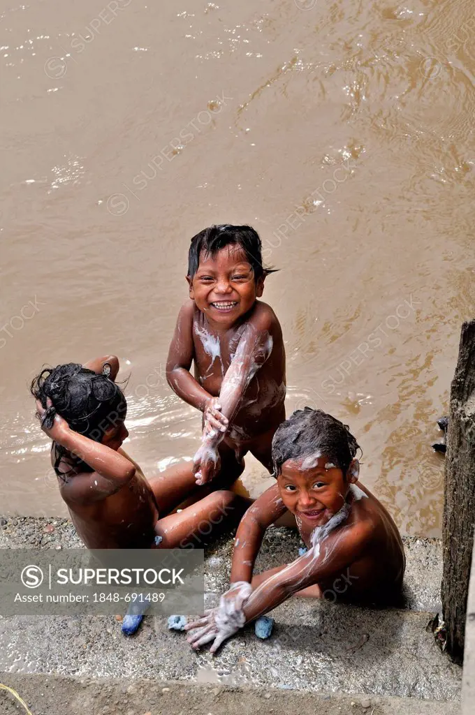 Indigenous children washing themselves in the Rio Madalena river, La Dorada, Colombia, South America