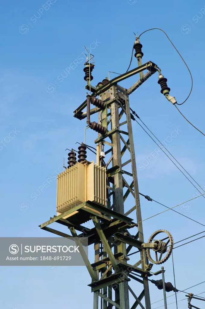 Power supply pylon with a transformer and insulators, with a tension sheave at the bottom to keep the lines taught