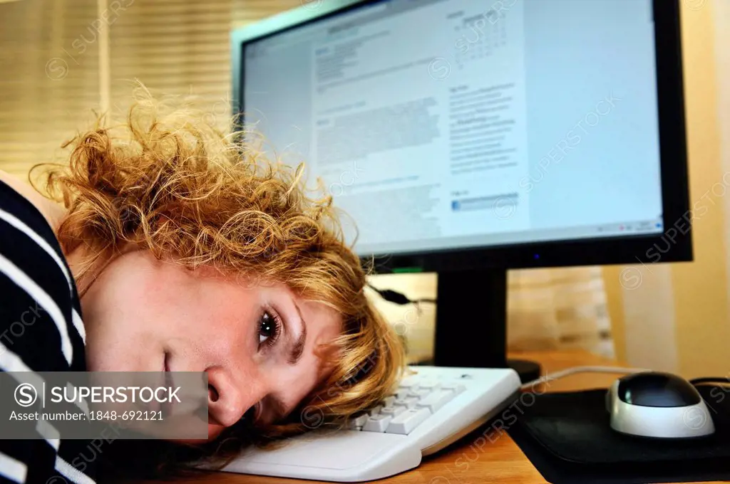 Exhausted woman resting head on PC keyboard, burnout