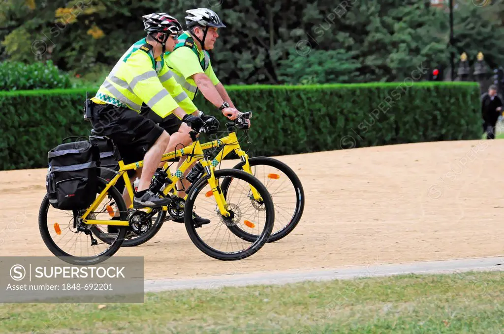 Two police officers on bicycles, bicycle patrol, in Hyde Park, London, England, United Kingdom, Europe