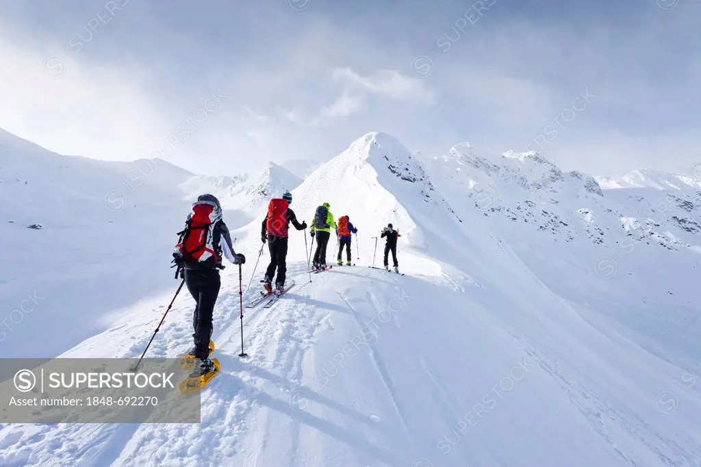 Snowshoe hikers climbing the Kleine Kreuzspitze peak in Racines above Sterzing, behind the Grosse Kreuzspitze peak, South Tyrol, Italy, Europe