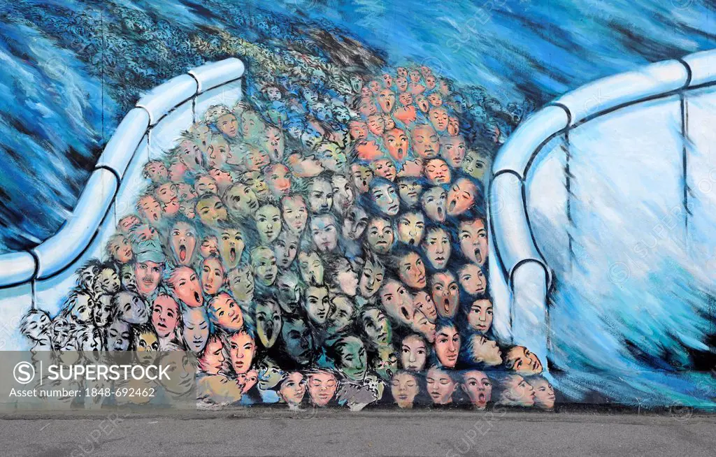 Art and the Berlin Wall, crowds breaking through the Berlin Wall, painting on a remaining segment of the Berlin Wall, East Side Gallery, Friedrichshai...