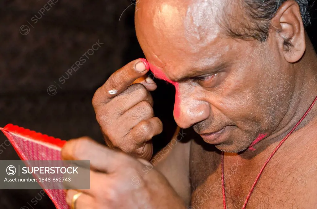 The make-up of the Kathakali character Ravana is being applied, Perattil, Kerala, India, Asia