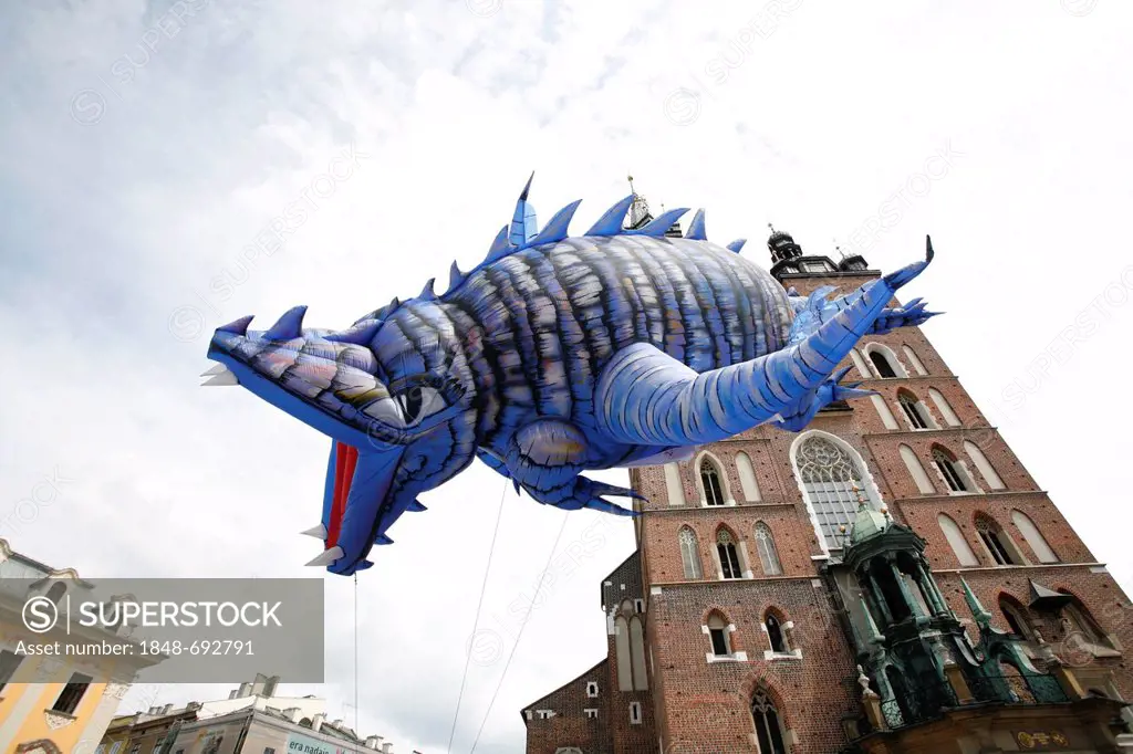 Flying dragon figure during a parade in front of a church, market square, Krakow, Poland, Europe