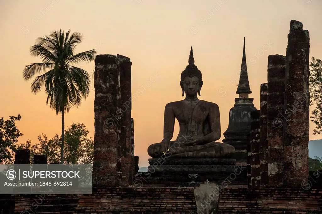 Silhouette of a seated Buddha statue at dusk, Wat Mahathat temple, Sukhothai Historical Park, UNESCO World Heritage site, Northern Thailand, Thailand,...