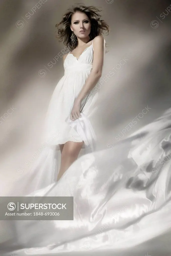 Young woman wearing a white dress with billowing fabric, fashion