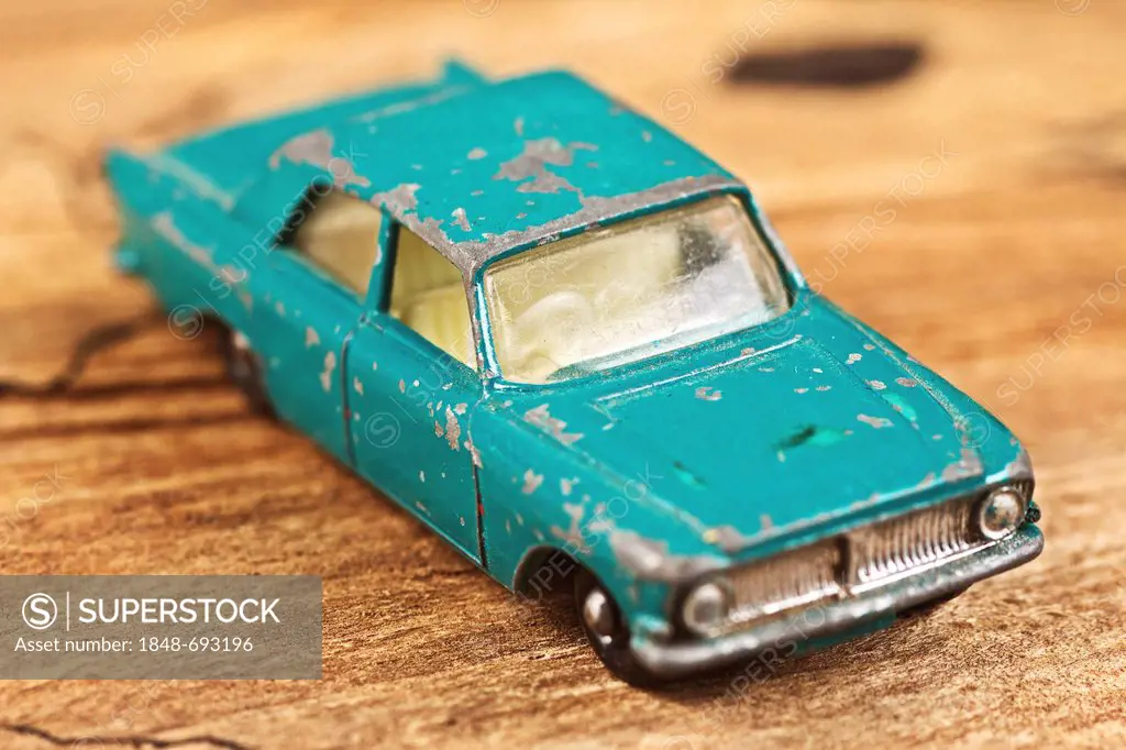 Old toy car on a wooden board