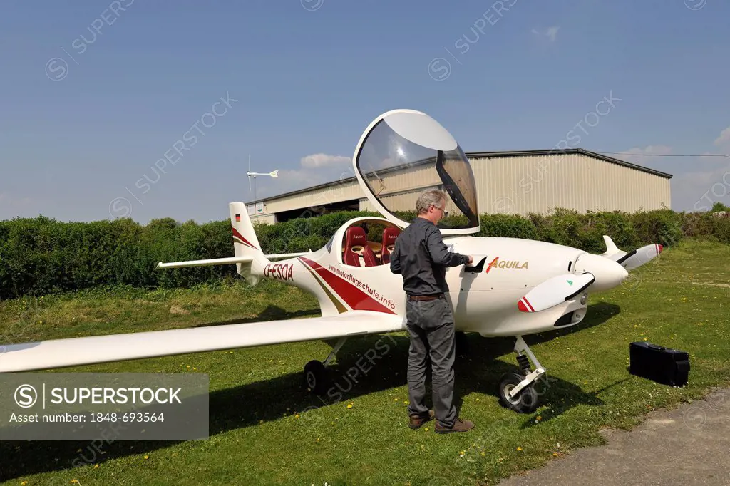 Pilot inspecting the cowling lid for measuring engine oil, light aircraft D-ESOA Aquila A210 AT01, Airport Hahnweide, Kirchheim unter Teck, Baden-Wuer...