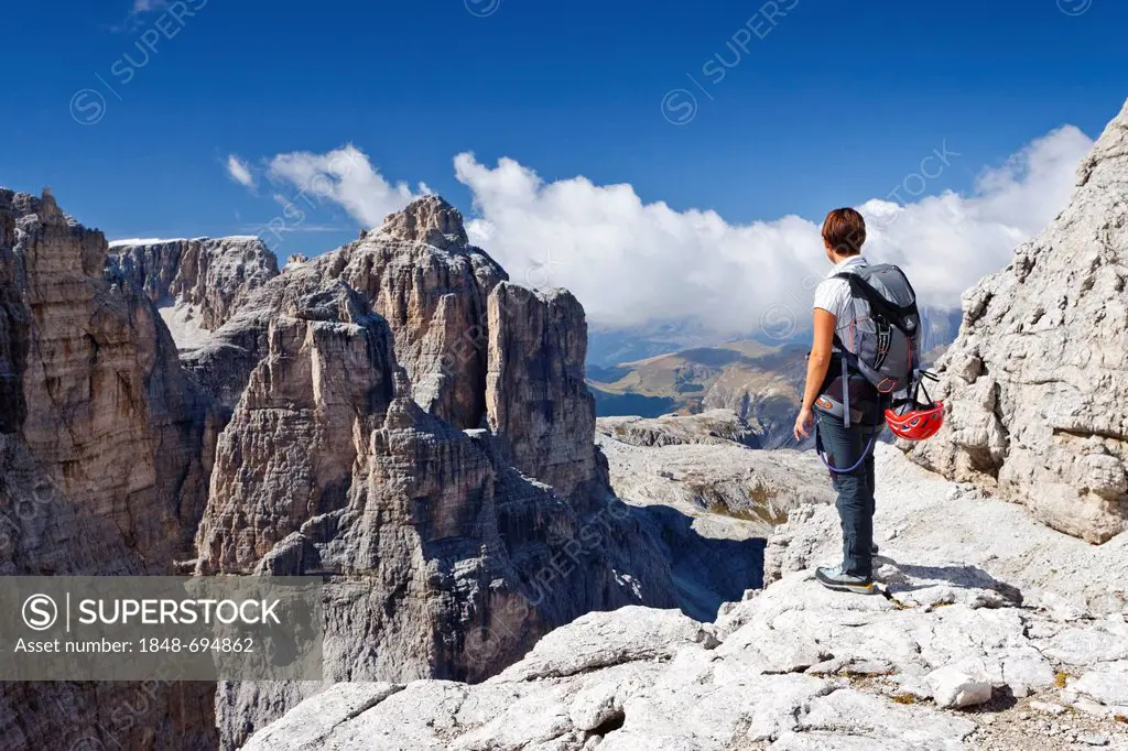 Climber on the Boeseekofel fixed rope route, Dolomites, Pisciadu mountain at the back, province of Trento, Italy, Europe