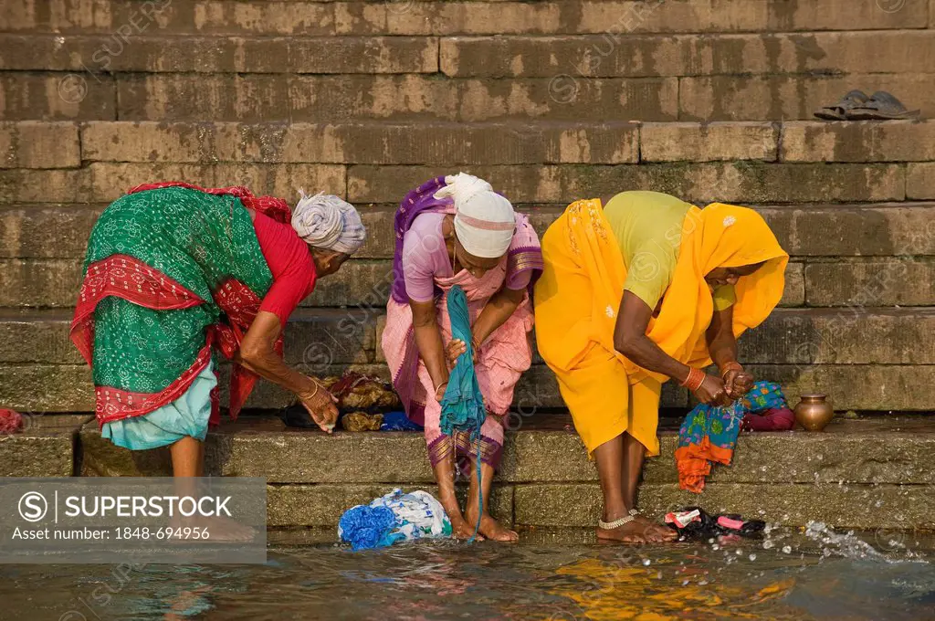 Women washing clothes on the Ghats or holy stairs, Ganges, Varanasi, Uttar Pradesh, India, Asia