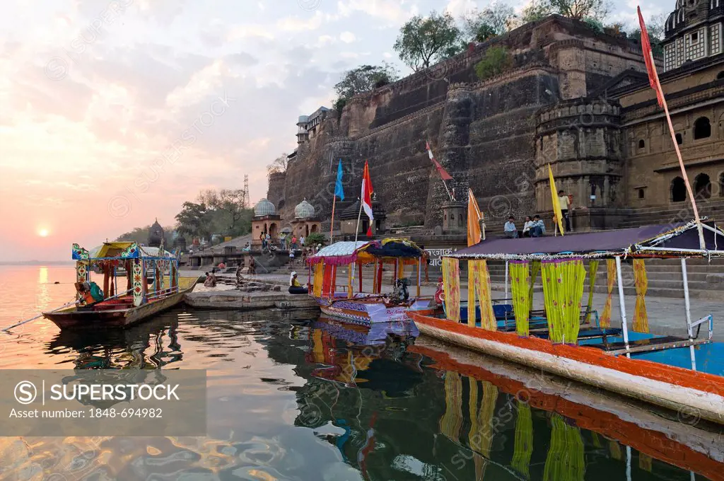Boats at the ghats holy steps, Narmada river, Maheshwar, Madhya Pradesh, India, Asia