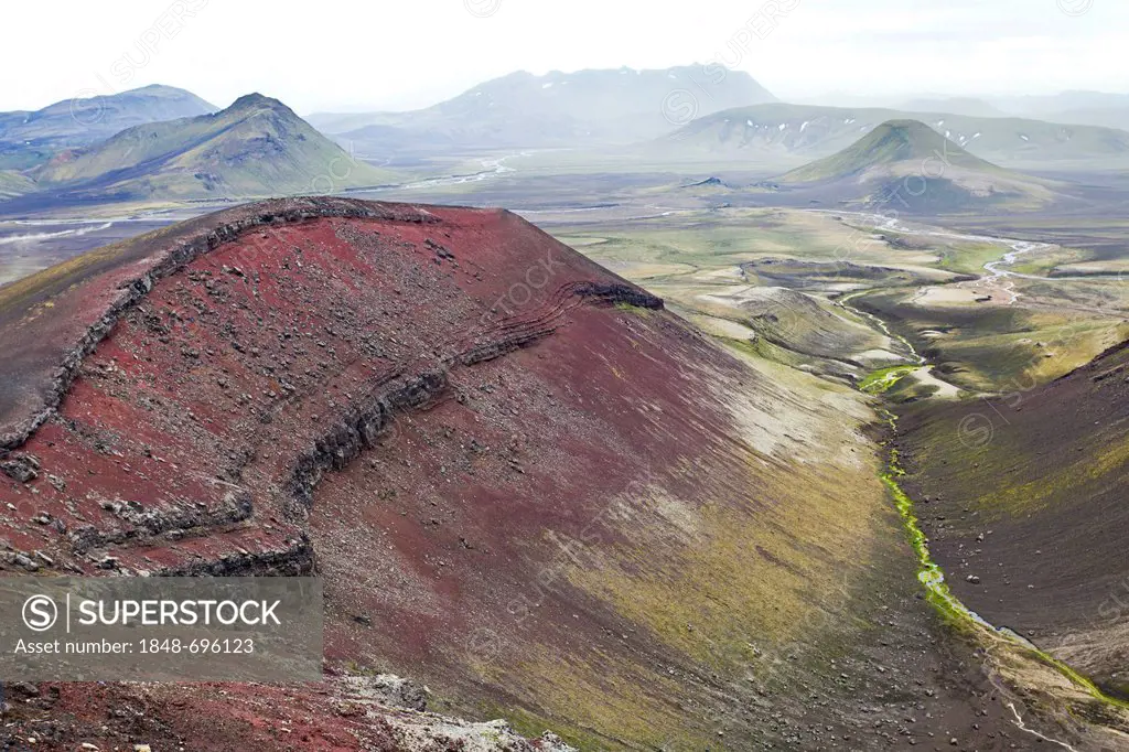 A red mountain, consisting of rhyolite rocks and minerals containing iron, surrounded by green, moss-covered mountains, Fjallabak nature reserve, High...