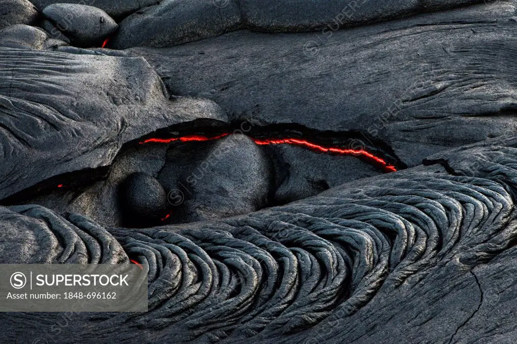 Viscous Pahoehoe lava flowing from rifts in the East Rift Zone towards the sea, lava field at the Kilauea shield volcano, Volcanoes National Park, Kal...