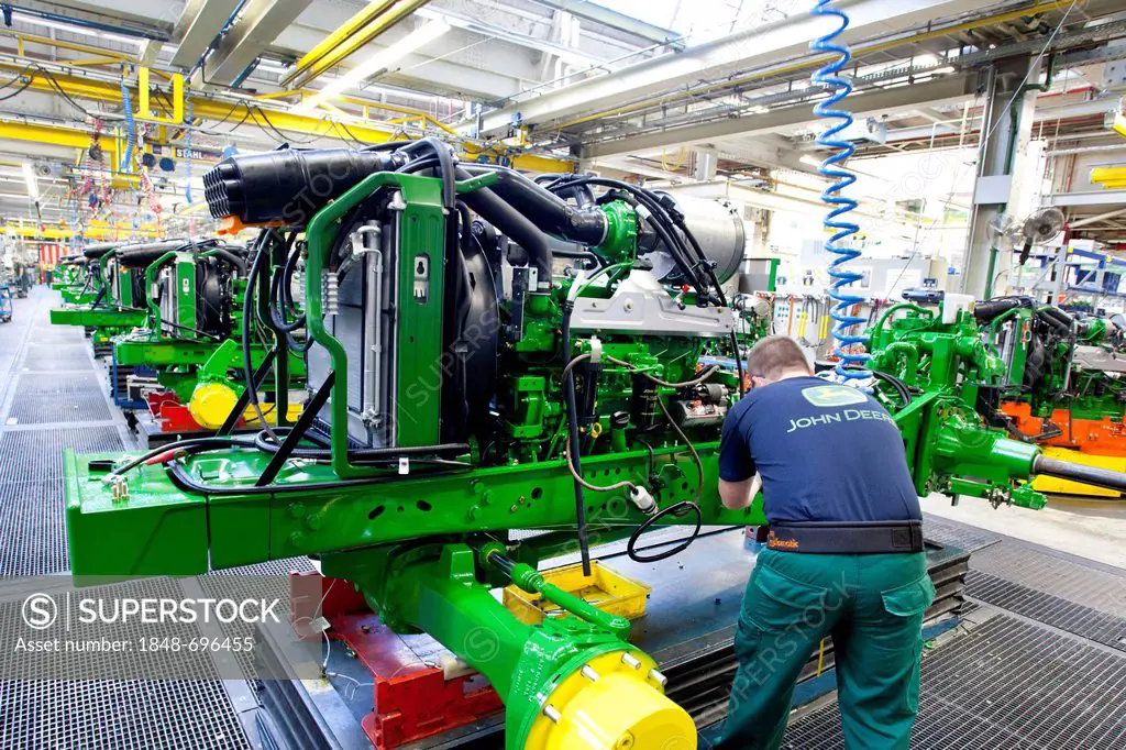 Engine is mounted to a frame in the engine assembly area of the tractor production section at the European headquarters of the American agricultural m...