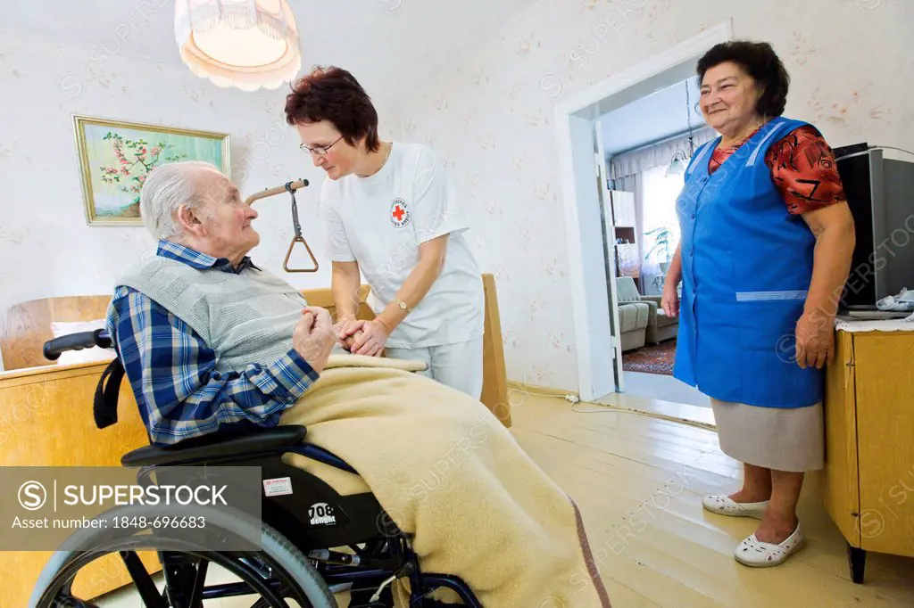 Ambulatory care of the German Red Cross, nurse Anke Lehmann attending an old married couple, as she does every morning, helping the wife to lift her h...