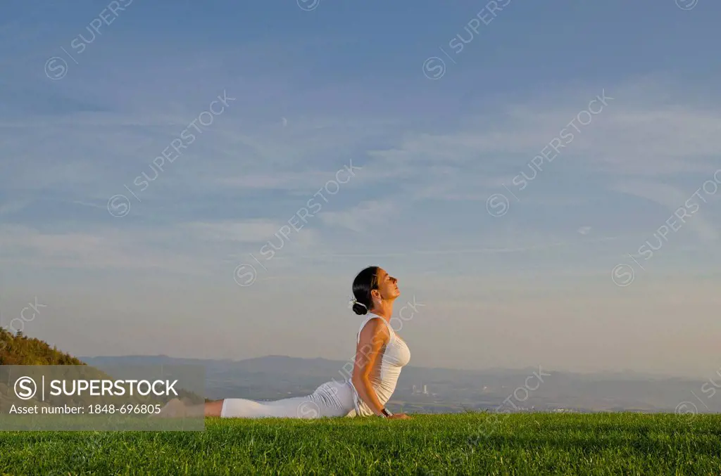 Young woman practising Hatha yoga outdoors, showing the pose bhujangasana, cobra pose, Nove Mesto, Okres Teplice, Czech Republik, Europe