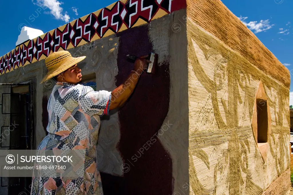 Woman painting the facade of a house, Basotho Cultural Village, Golden Gate National Park, Free State, South Africa, Africa
