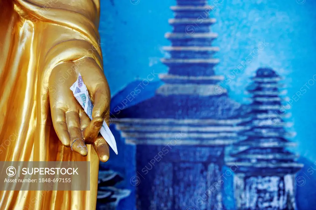 Hand of a Buddha statue holding a banknote, donation, temple, Yangon, Myanmar, Burma, Southeast Asia, Asia