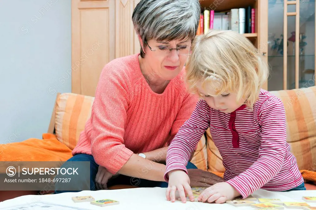 Grandmother and her granddaughter playing together at a table