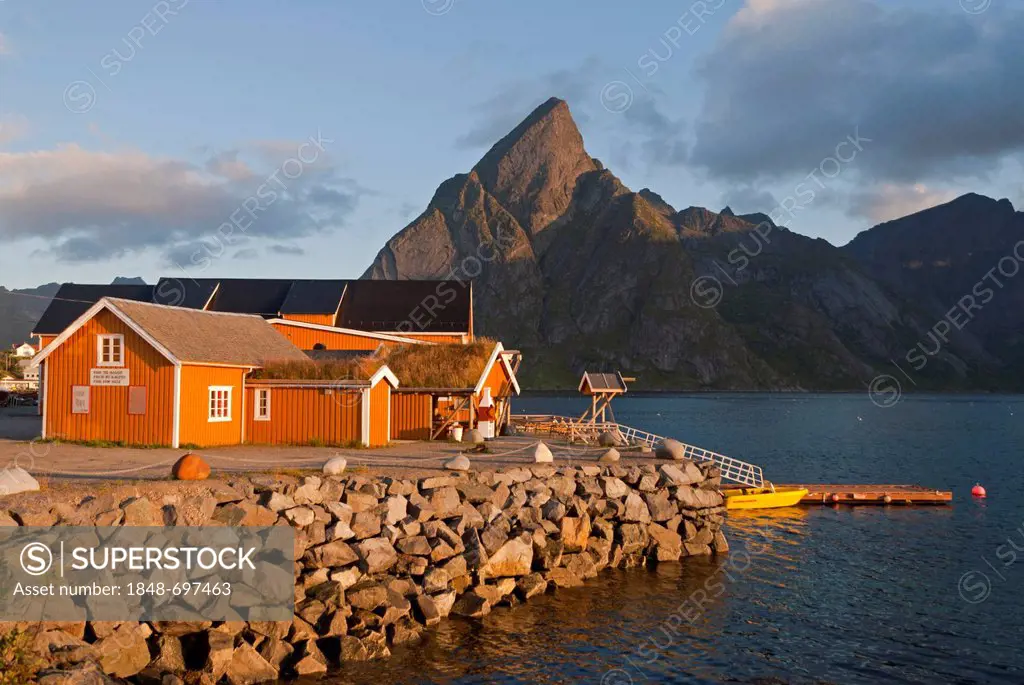 Rorbuer huts, rorbu, of the tiny village Sakrisøy, Sakrisoy, mountains at back, island of Moskenesøy, Moskenesoy, Lofoten archipelago, Nordland, Norwa...