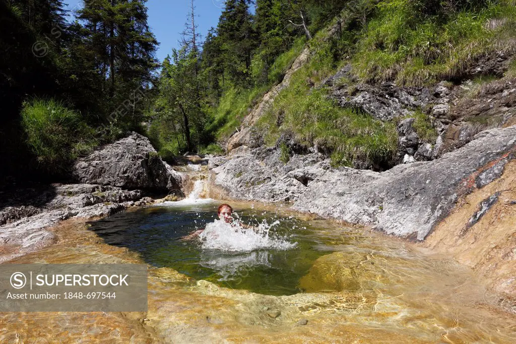 Woman bathing in a rock pool at Schronbach stream, Schronbachtal valley, municipality of Jachenau, Isarwinkel, Upper Bavaria, Germany, Europe