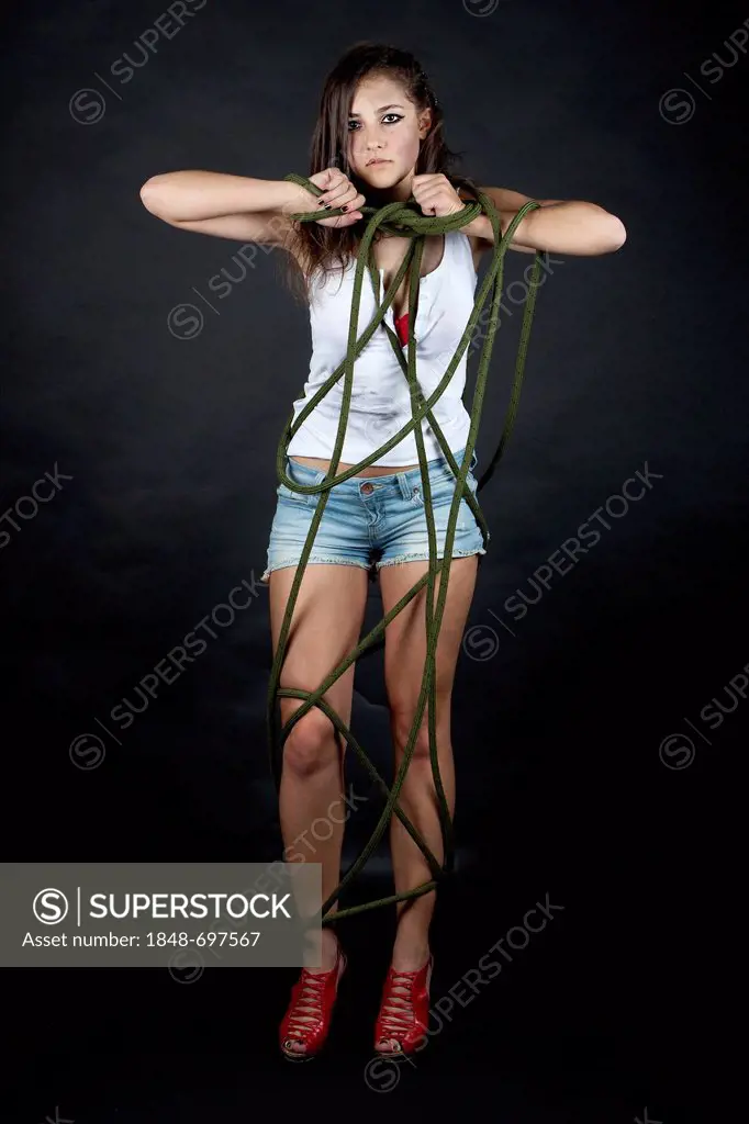 Young woman, dirty and tied up with rope