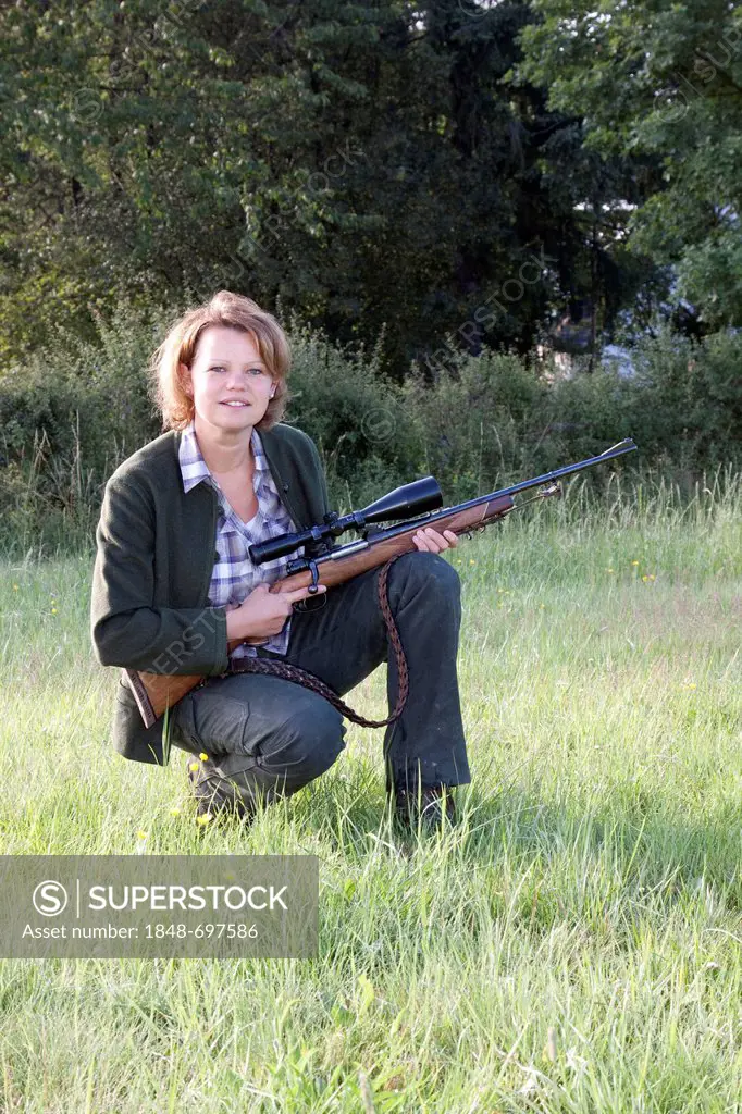 Female hunter with rifle wearing hunting clothes, Rhineland-Palatinate, Germany, Europe