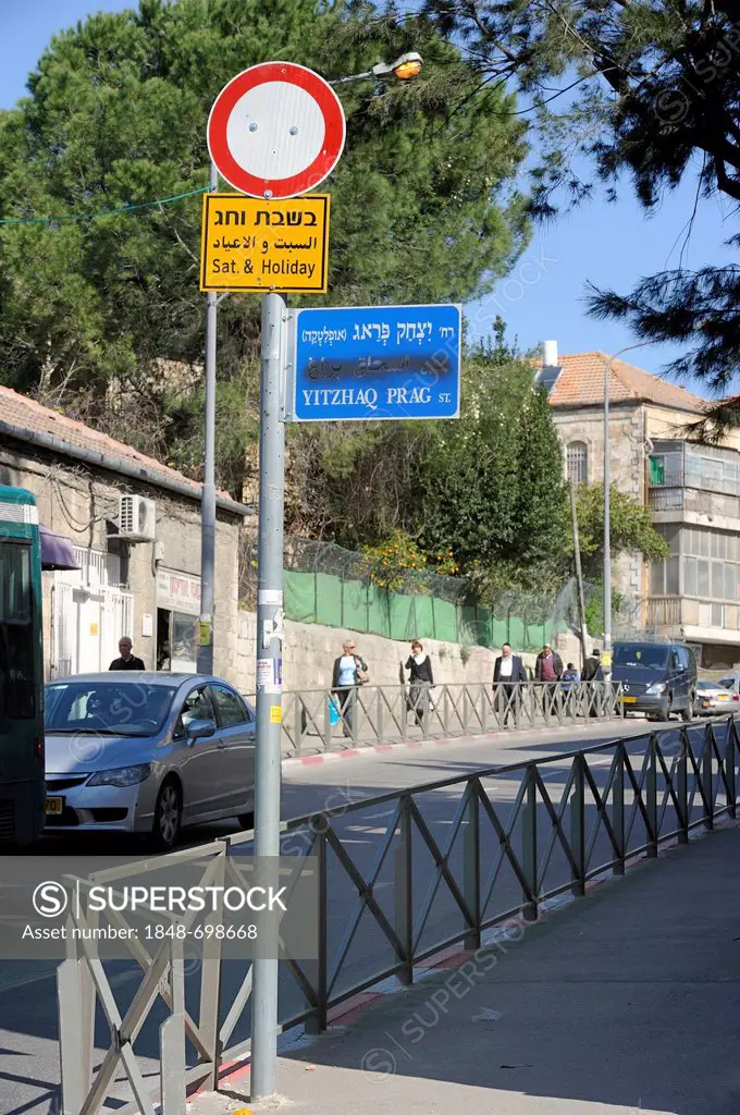 Street name sign with the Arabic name sprayed over, Orthodox Jews at the rear, Jerusalem, Israel, Middle East