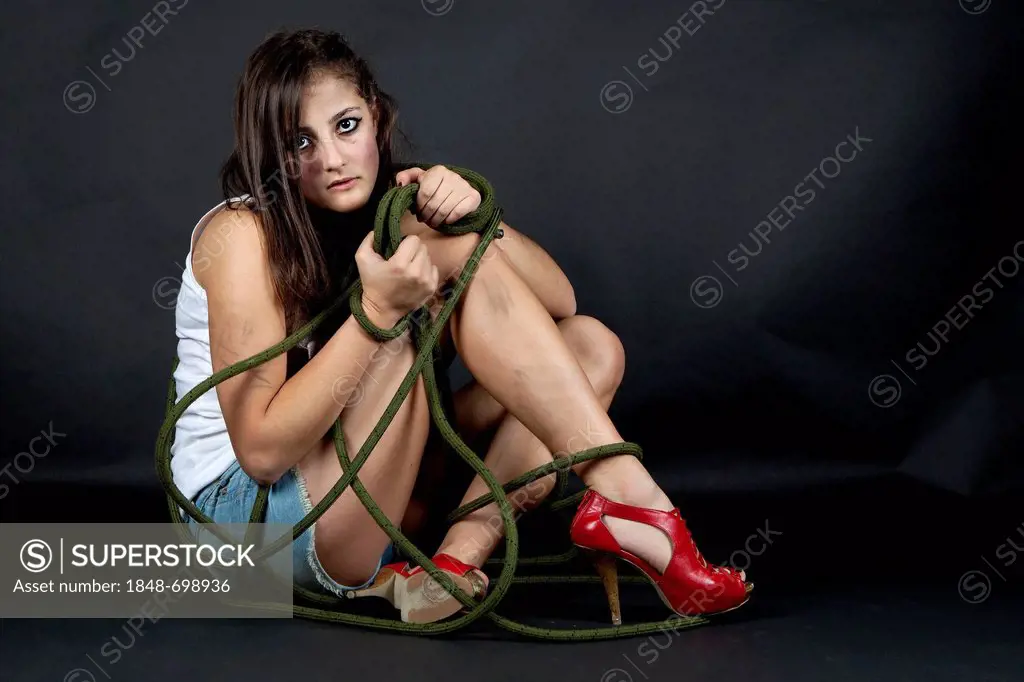 Young woman looking sad, dirty and tied up with rope