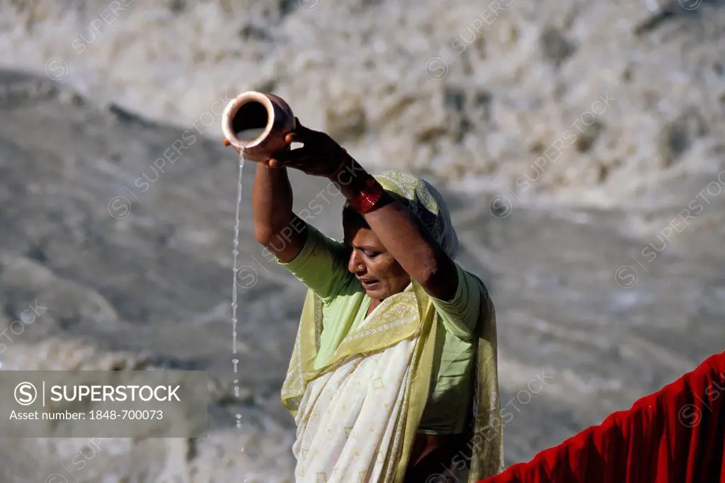 Woman performing a Hindu purification ritual, on the headwaters of the Ganges River, Gangotri, Indian Himalayas, Uttarakhand, formerly Uttaranchal, In...