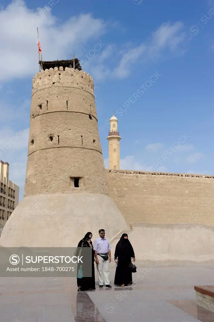 Arab man with his wives standing in front of the tower of the fort in Dubai, Dubai museum, United Arab Emirates, Arabia, Arabian Peninsula