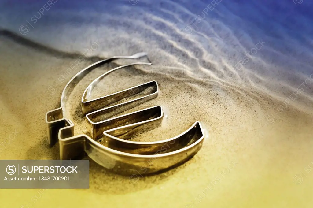 Euro symbol lying on a beach in the water, symbolic image for euro crisis