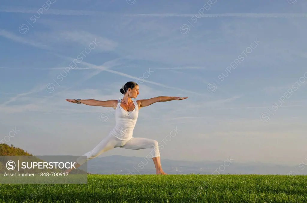Young woman practising Hatha yoga outdoors, showing the pose virabhadrasana II, proud warrior, Nove Mesto, Okres Teplice, Czech Republic, Europe