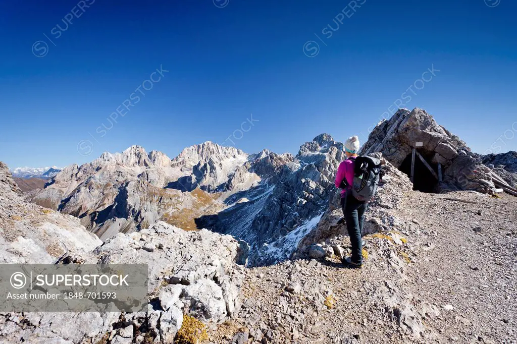 Hiker on Bepi Zac climbing route in the San Pellegrino Valley above the San Pellegrino Pass, currently on Costabela Mountain, with the Marmolada at th...
