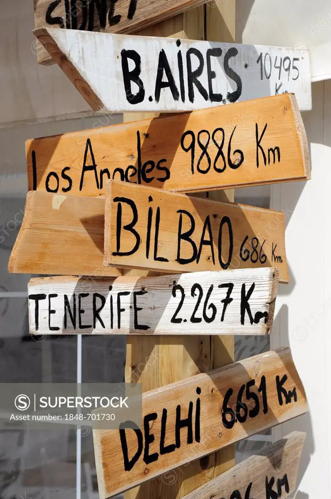 Signposts to Buenos Aires, Bilbao, Tenerife and Delhi outside a shop in Fornells, Minorca, Menorca, Balearic Islands, Mediterranean Sea, Spain, Europe