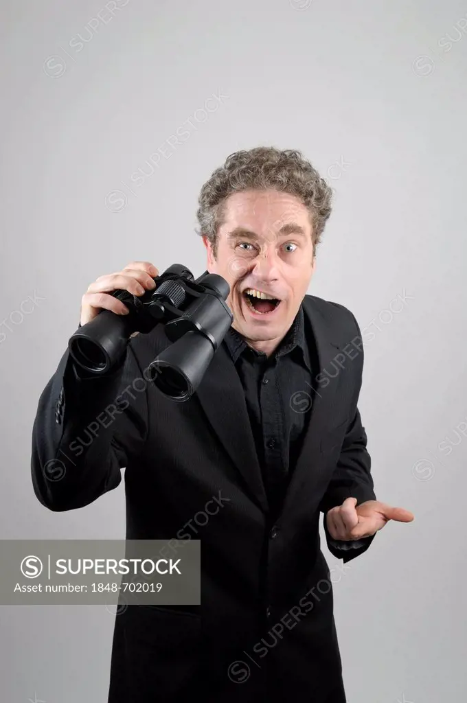 Businessman wearing a black suit with binoculars