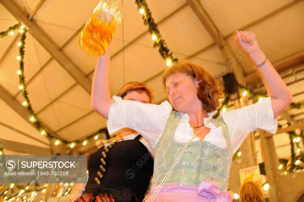 Women wearing traditional costume dancing on a table in a beer tent, Rosenheim autumnal festival, Bavaria, Germany, Europe