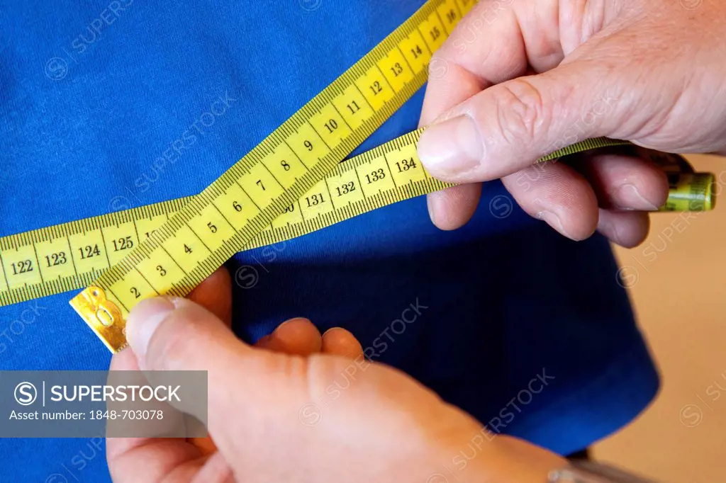 Measurement of body circumference, abdominal measurement, with a tape measure, prior to a workout at the fitness centre, Regensburg, Bavaria, Germany,...