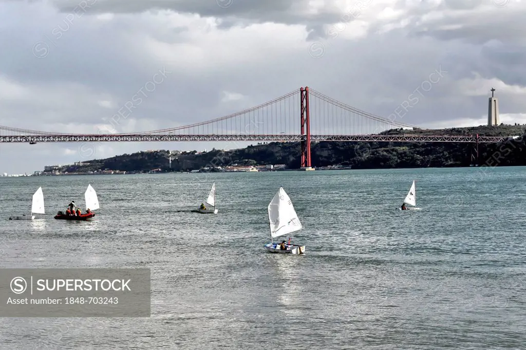 Ponte 25 de Abril, bridge over the Rio Tejo, Tagus river, inaugurated 1966, suspension bridge, boats of a sailing school at front, Alcantara, Lisbon, ...