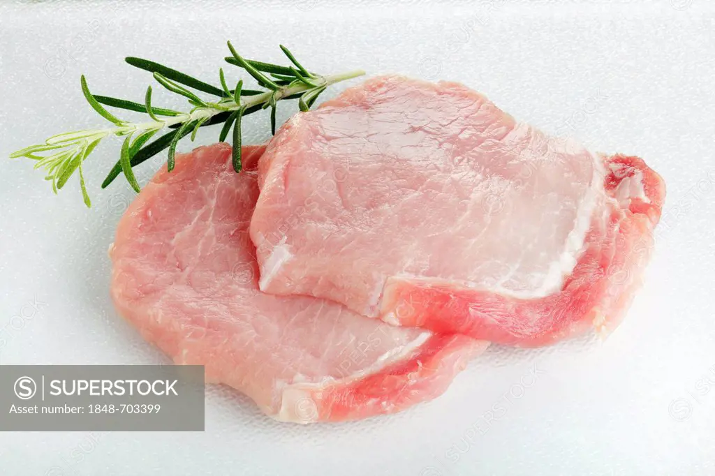 Raw pork loin steaks, rosemary leaves