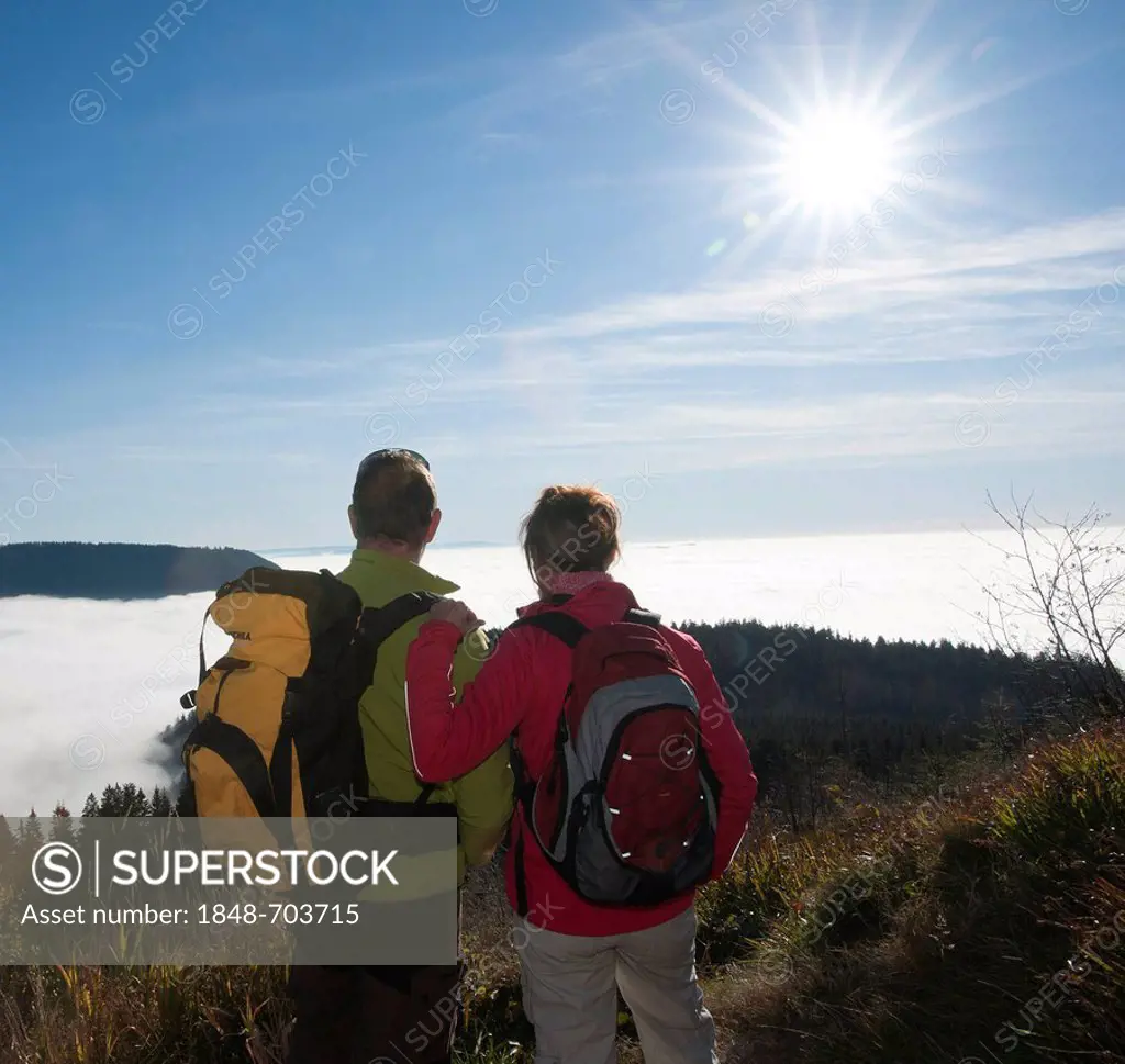 Couple on a hiking trip looking at a fog shrouded valley, Black Forest, Baden-Wuerttemberg, Germany, Europe