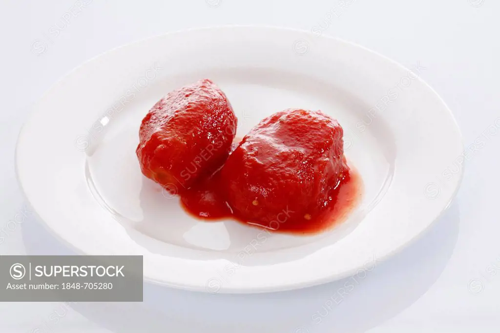 Two peeled canned tomatoes on white plate
