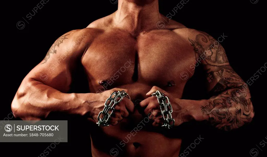 Torso of a bodybuilder, his hands in chains