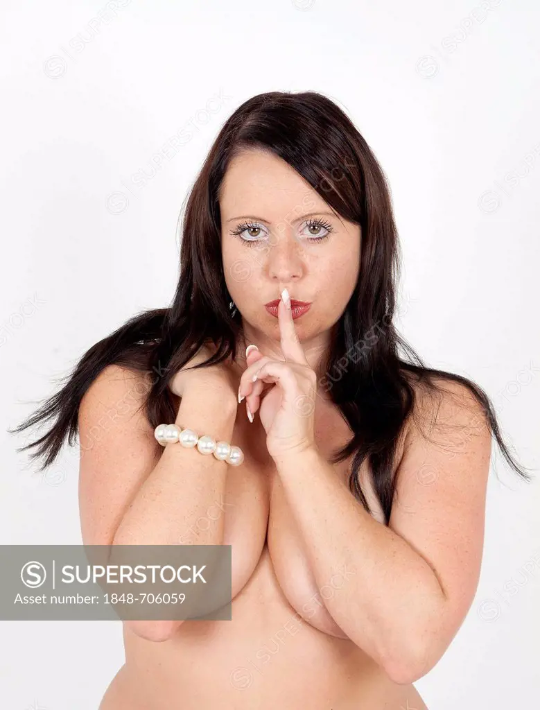 Young woman standing bare-chested with her finger in a gesture of silence