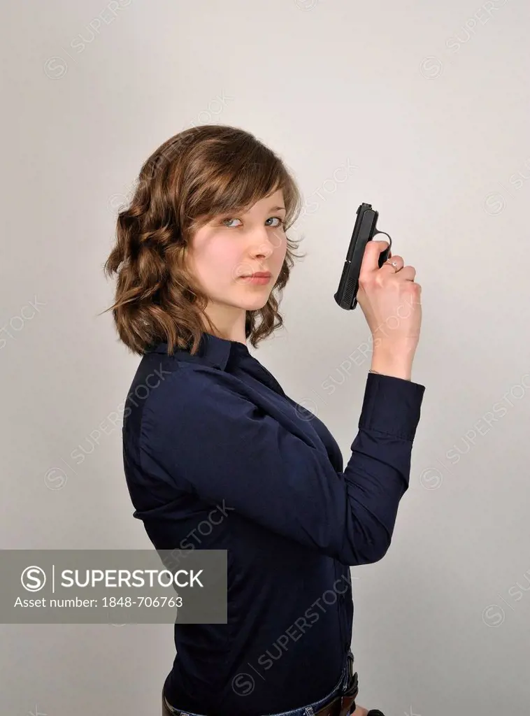 Young woman, 20, holding a pistol