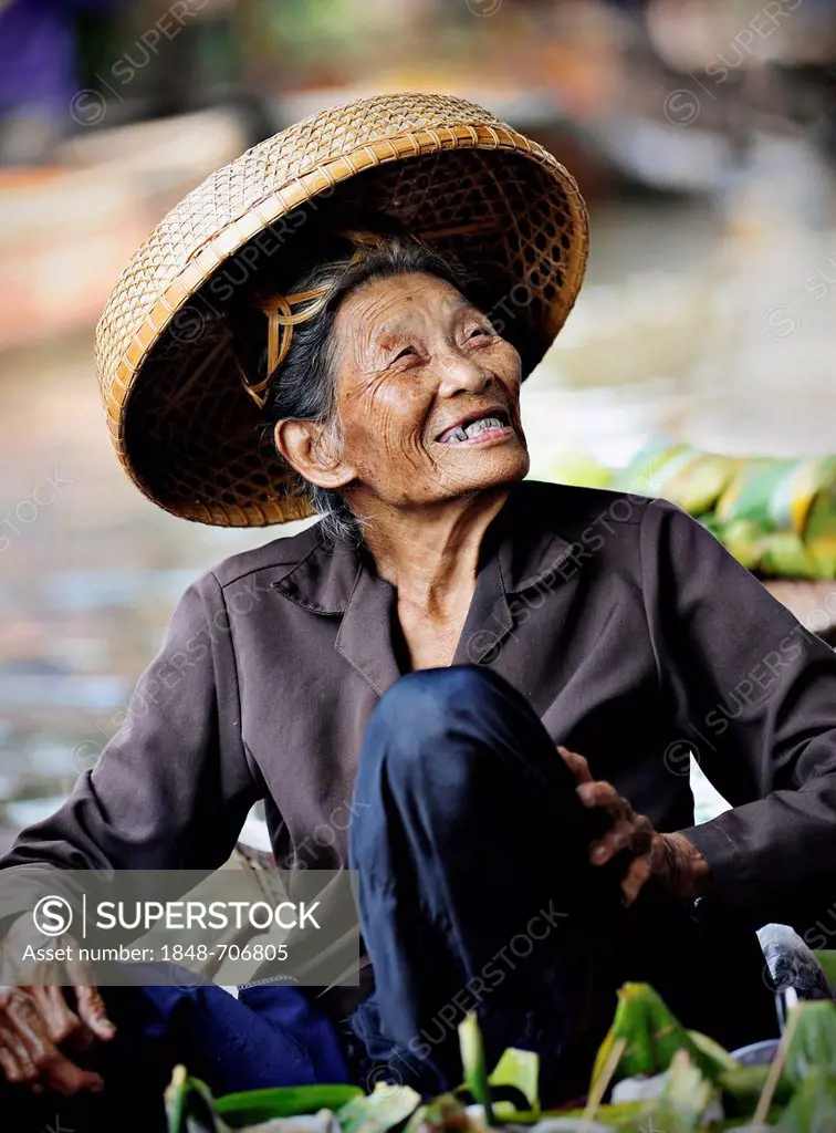 Smiling old woman wearing a straw hat at the floating market, Damnoen Saduak, Thailand, Southeast Asia, Asia