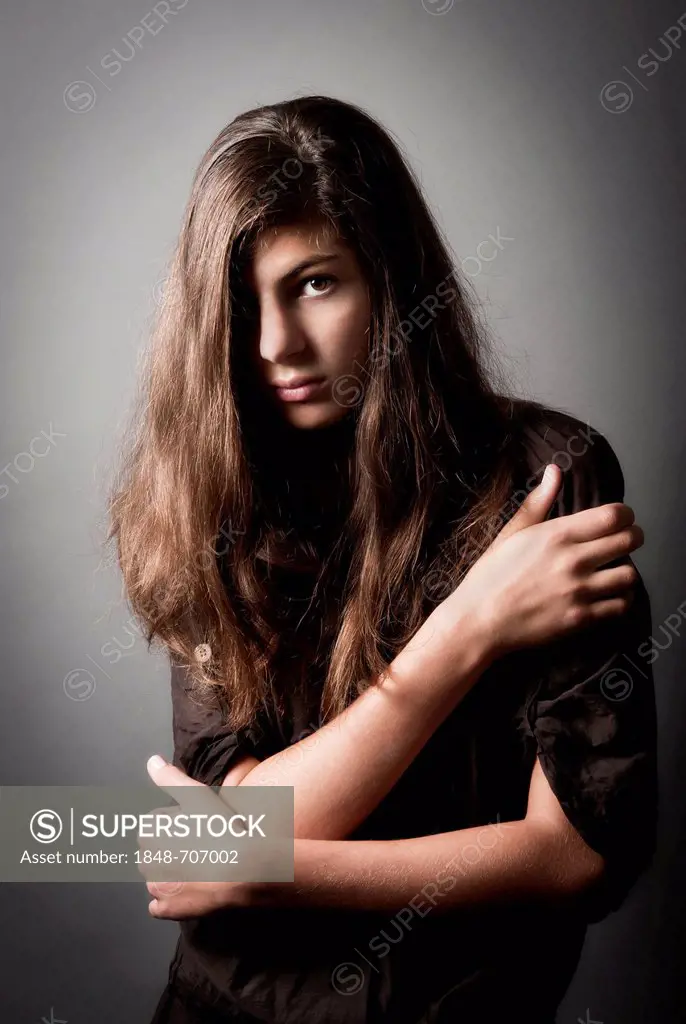 Pensive girl, aged 13, with long hair, portrait