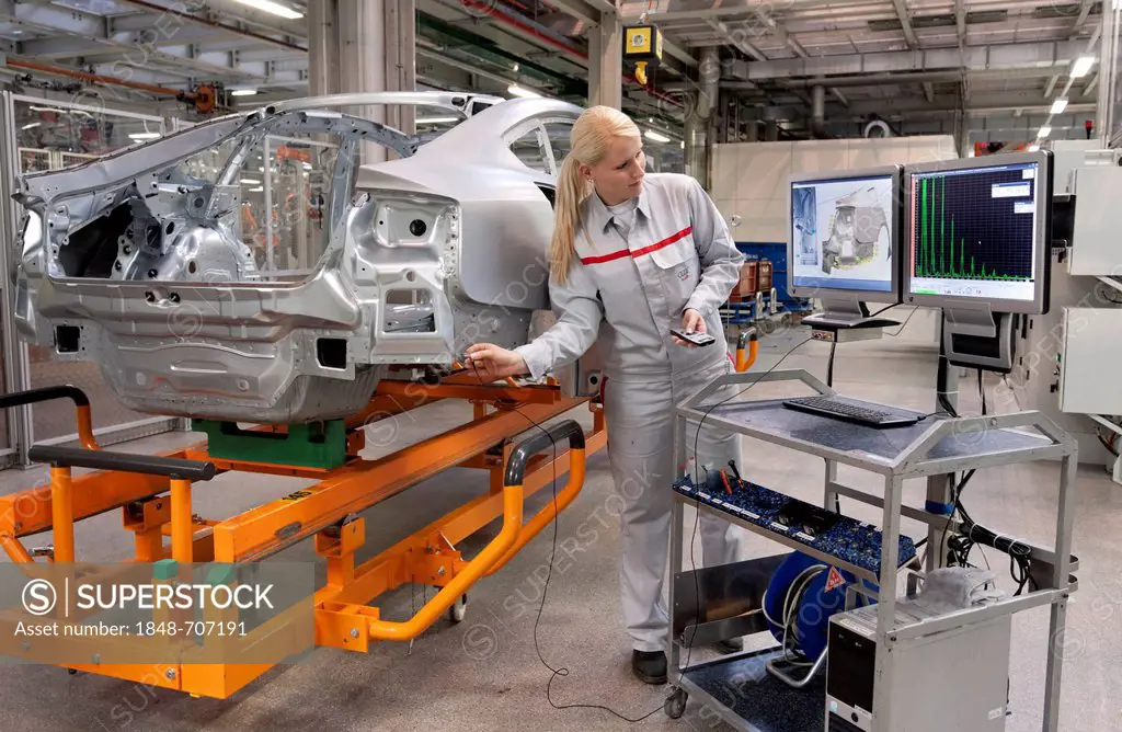 An Audi employee checking welding spots on a car body set by robots with a sensor, Audi plant in Ingolstadt, Bavaria, Germany, Europe