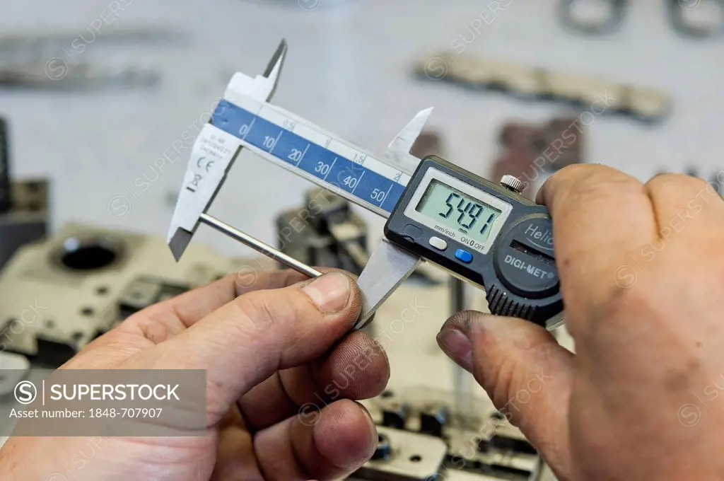 Taking a measurement with calipers, tool production